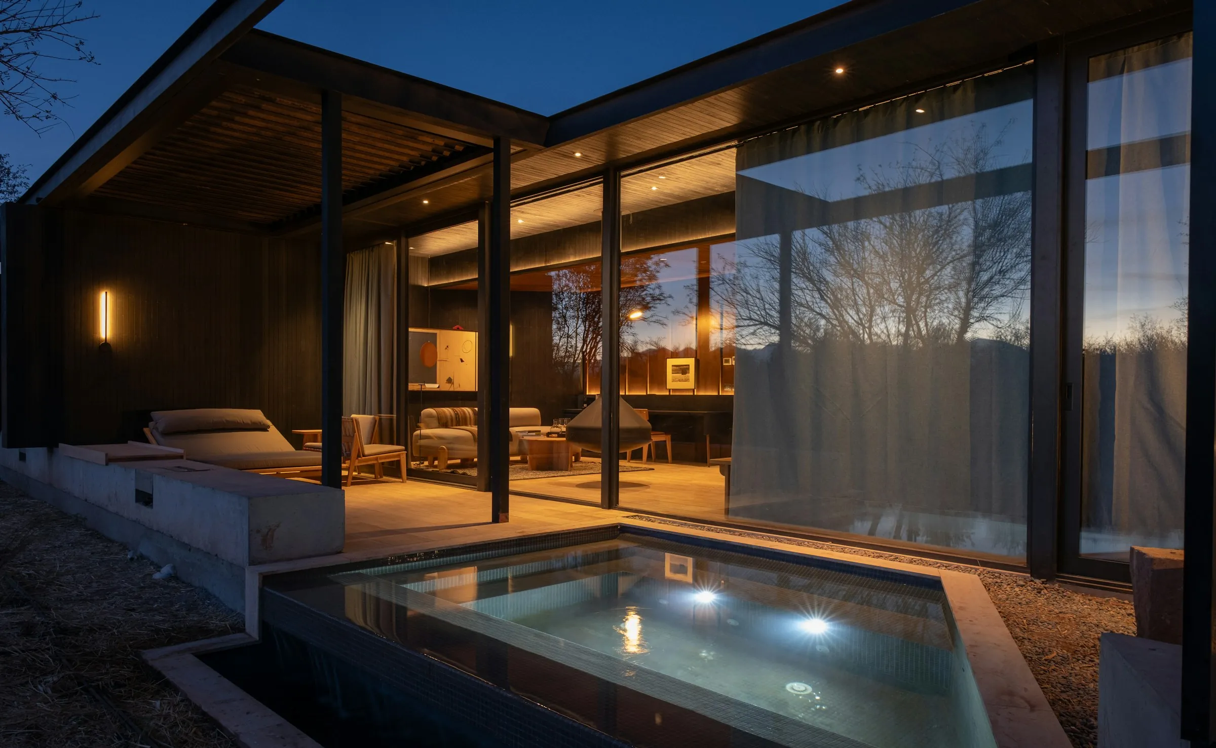 Glass-walled modern home at dusk